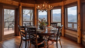 A wooden dining room with a large table set for six, surrounded by chairs. - The Sanctuary-Pet Friendly Luxury Cabin Rental, Sits on Top of the Mountain, High Speed Internet, Hot Tub, 30 Minutes to Great Smoky Mountains, in Nantahala NC (Topton)