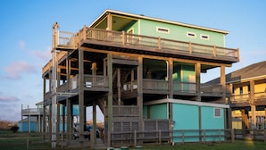 A multi-level wooden structure with balconies, likely a vacation rental or a houseboat.