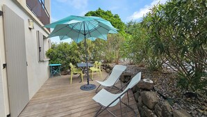 A wooden deck with outdoor furniture, including chairs and a table, under a large umbrella. - Les Lauriers Roses: Heated pool, unspoilt nature (Saint-Vincent-de-Barrès)