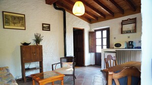 A cozy living room with a wooden cabinet, a sofa, a coffee table, and a dining area with a table and chairs. - Casa 3/Andalusian architecture in a beautiful green oasis/1 km from El Borge (El Borge)