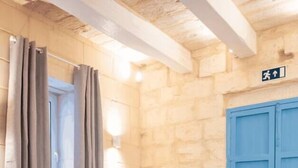 Une pièce chaleureuse avec un canapé bleu foncé, une petite table et une porte bleue.