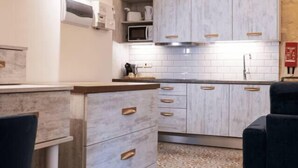 Une cuisine moderne avec des armoires blanches, un four à micro-ondes encastré et un sol à motifs.