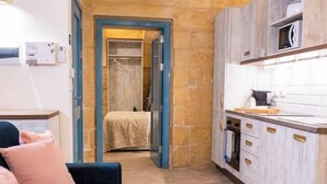 A compact living space with a sofa, a kitchenette, and a small dining area.