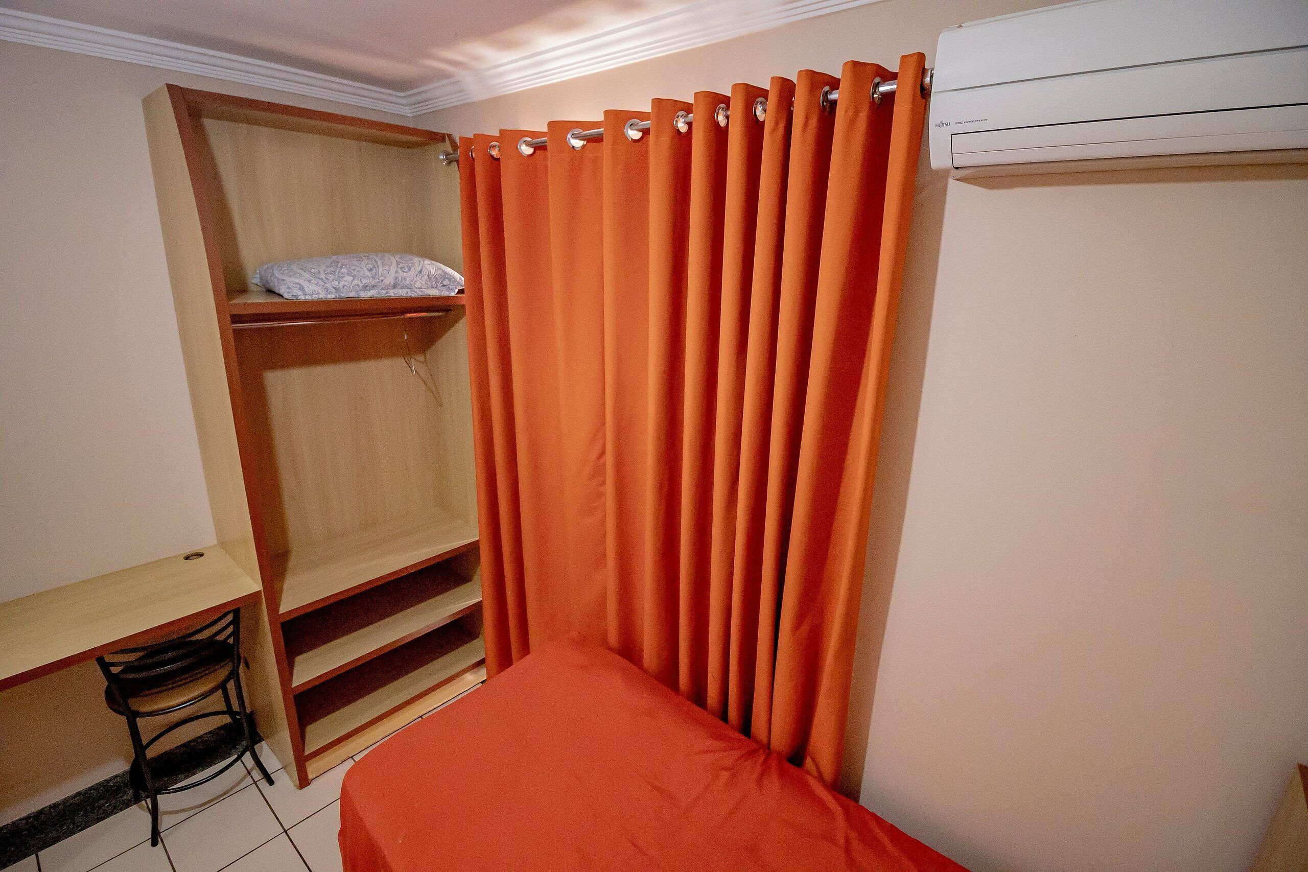 Une chambre avec un lit, un bureau et une armoire.