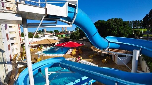 Een waterpark met meerdere glijbanen en zwembaden, een toezichtsstandplaats en buitenzitgedeeltes.