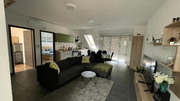 Ein modernes Wohnzimmer mit einer Eckcouch, einem Couchtisch und einer TV-Konsole.