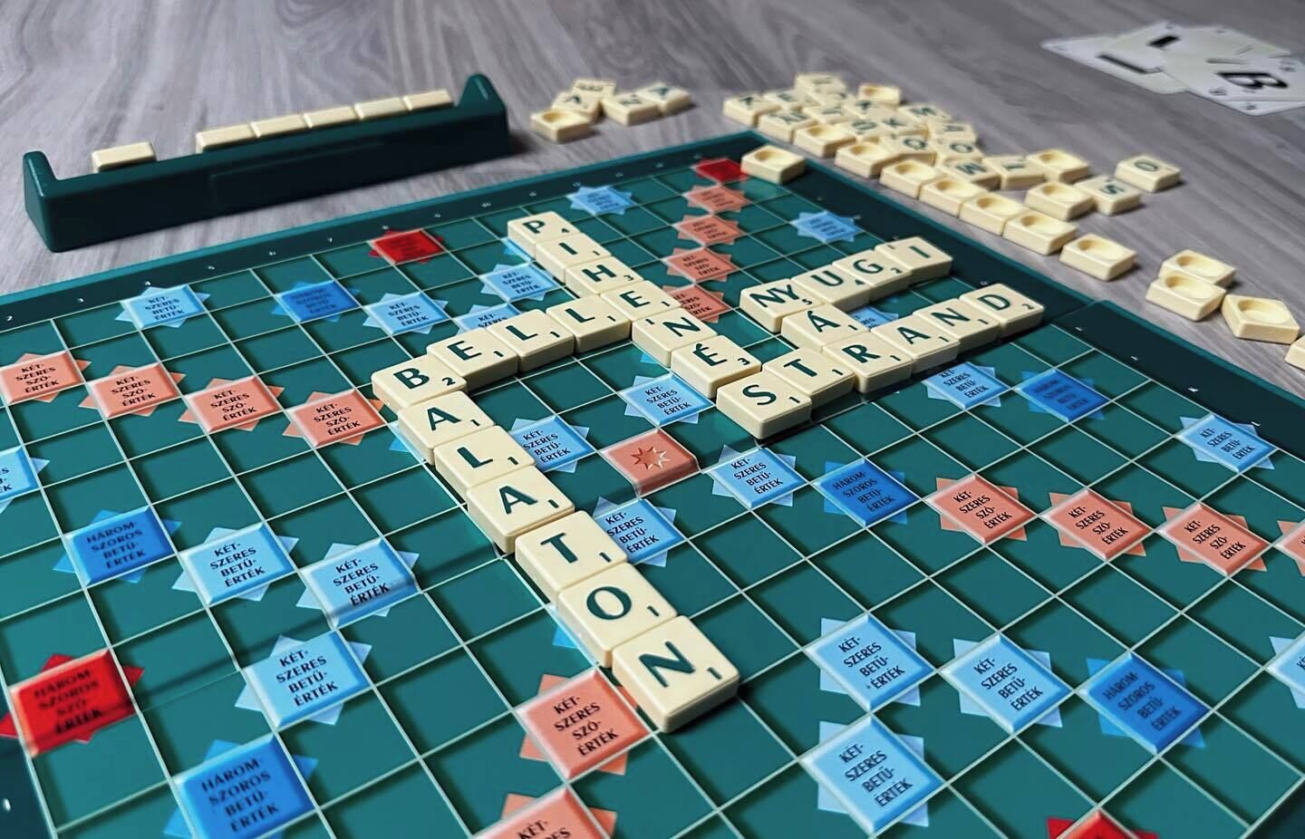 En Scrabble-spelplan med brickor och bokstäver som är arrangerade för att stava ordet ”BALALON”.