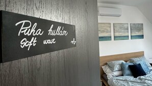 Ein Schlafzimmer mit einem Bett, Kissen und einem an der Wand befestigten Schild mit Text.