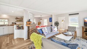 Un amplio espacio de sala con sofá, mesa de centro y televisor.