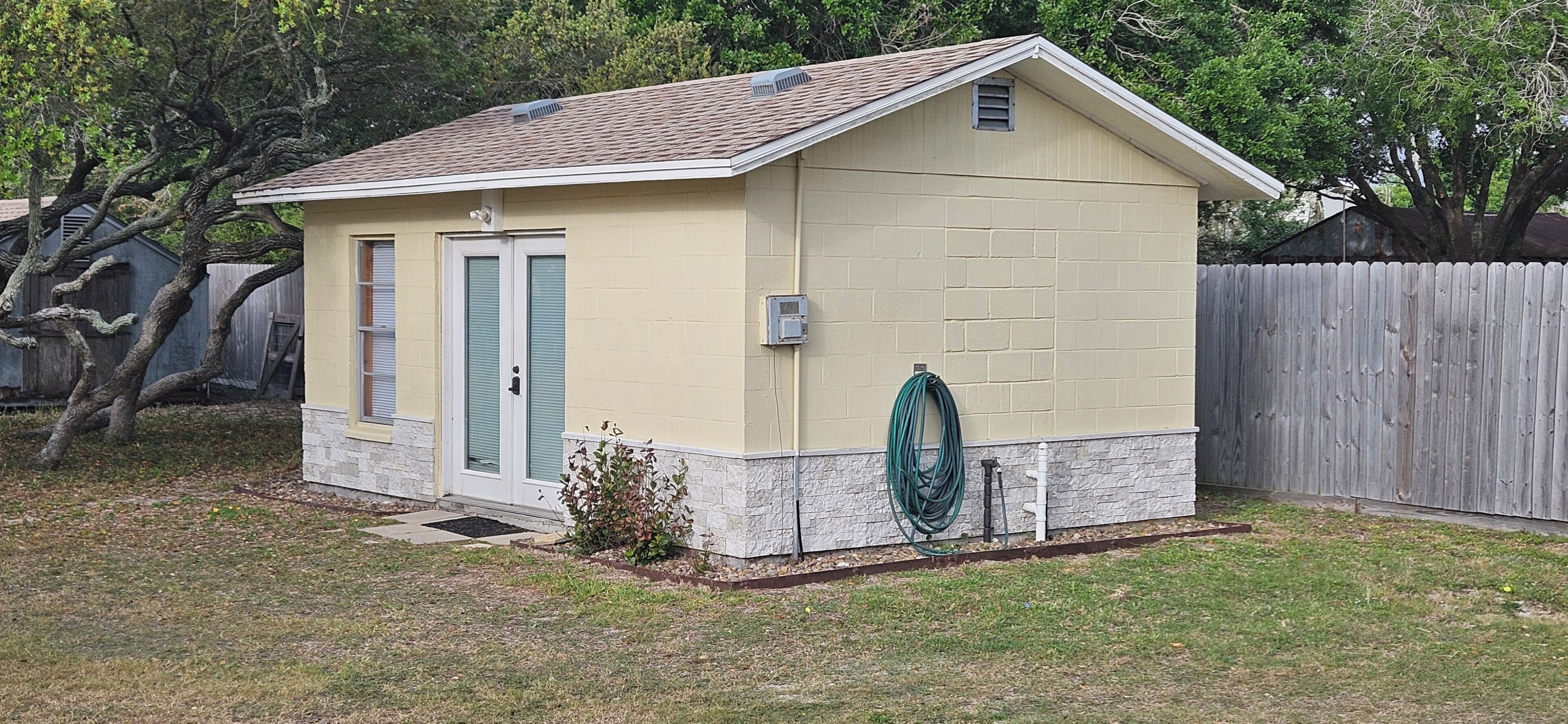 A small, single-story building with a sloped roof, a door, and a window.