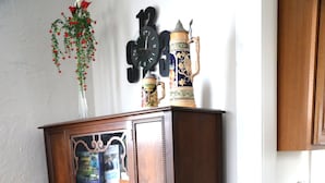 A wooden dining table with a chair, a wooden cabinet with glass doors, and a wall clock. - Cedar Point - Sandusky Themed House (Sandusky)