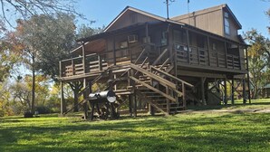 Une cabane en bois dotée d’un balcon et d’une grande structure tubulaire à l’avant.