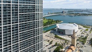 A high-rise building with multiple floors and a large, modern stadium with a dome and a tower.