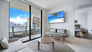 A modern living room with a sofa, a coffee table, and a TV on the wall.