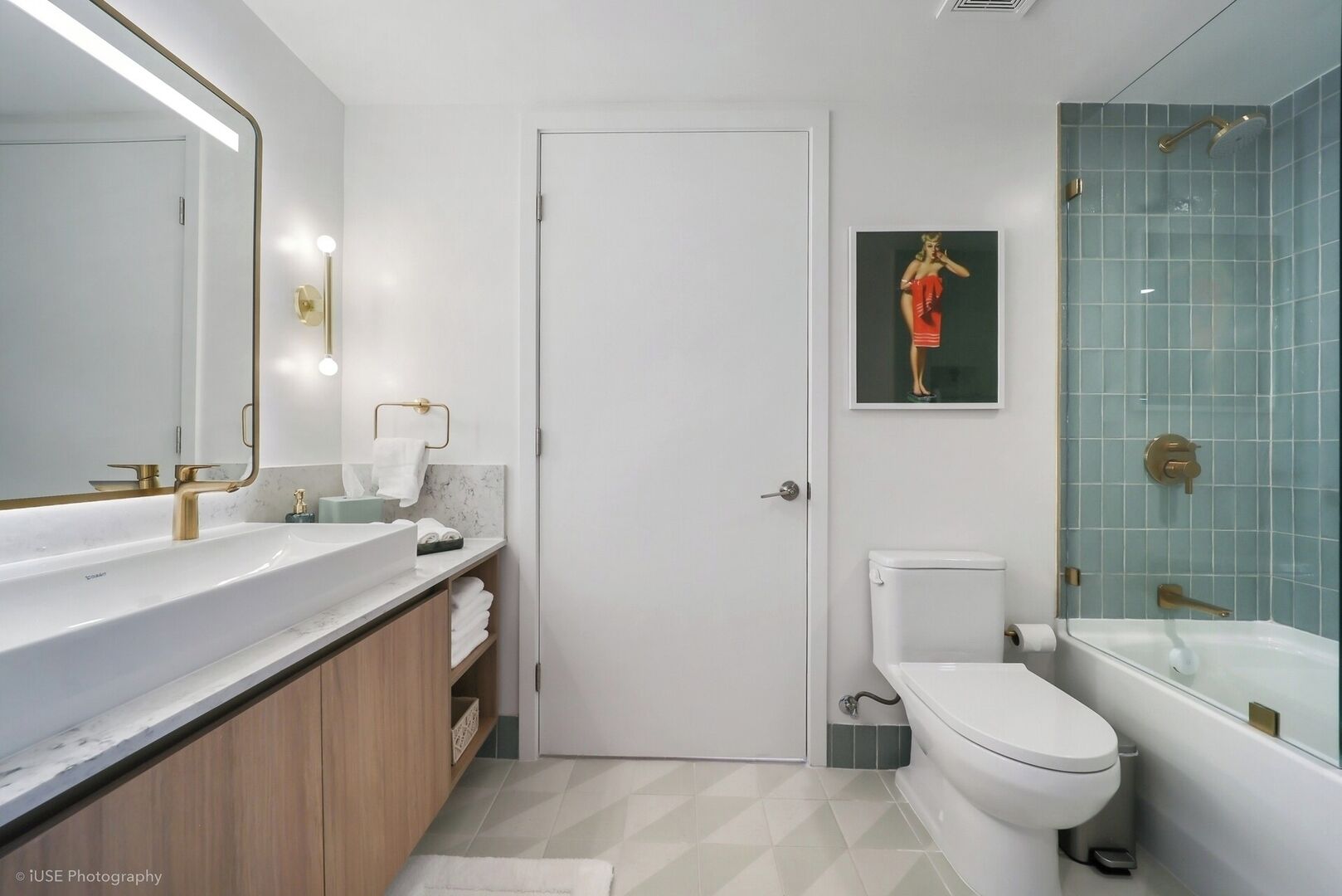 Une salle de bain moderne avec un grand miroir, un lavabo, des toilettes et une douche.