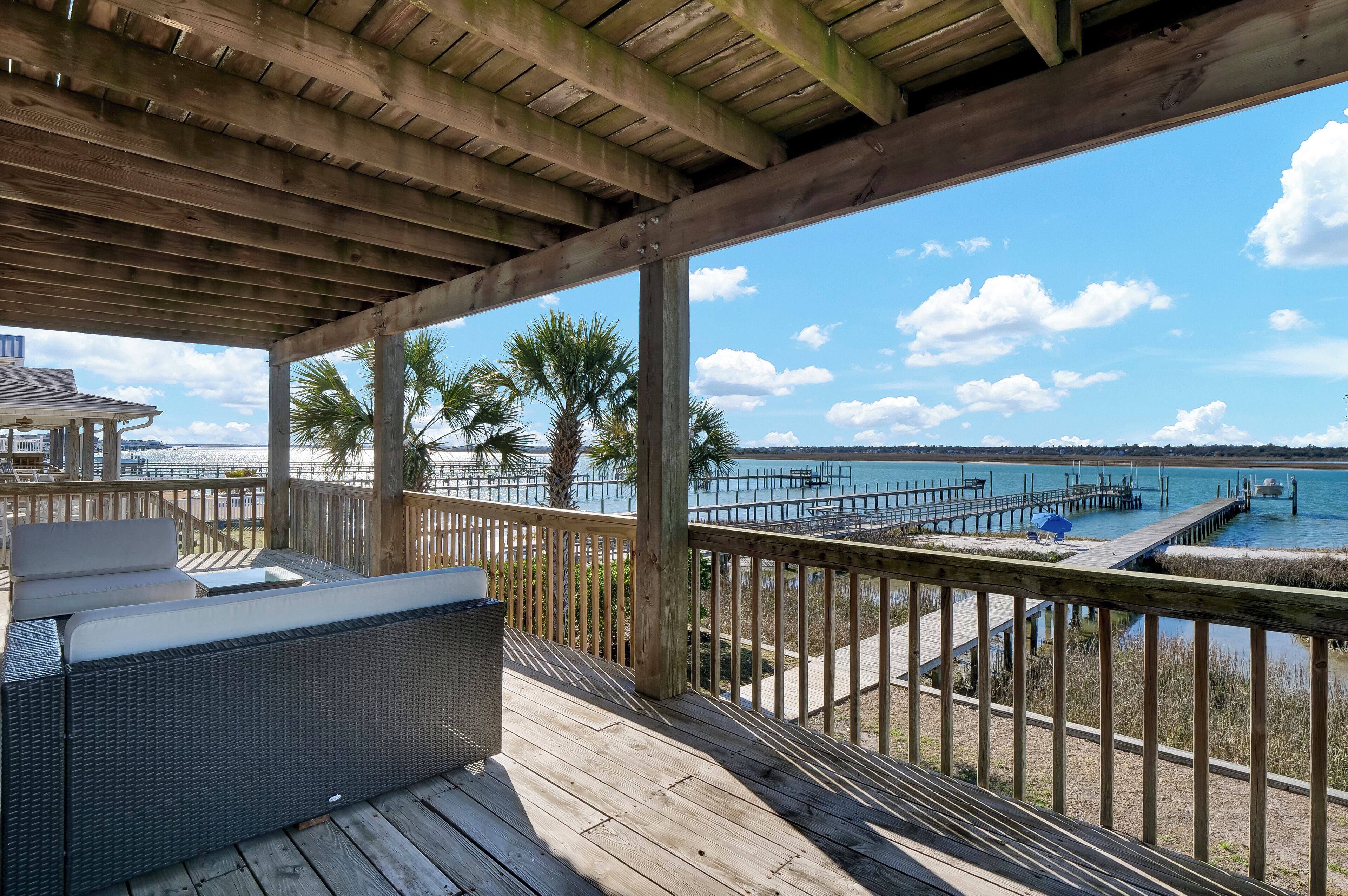 A wooden deck with outdoor seating and a view of the water.