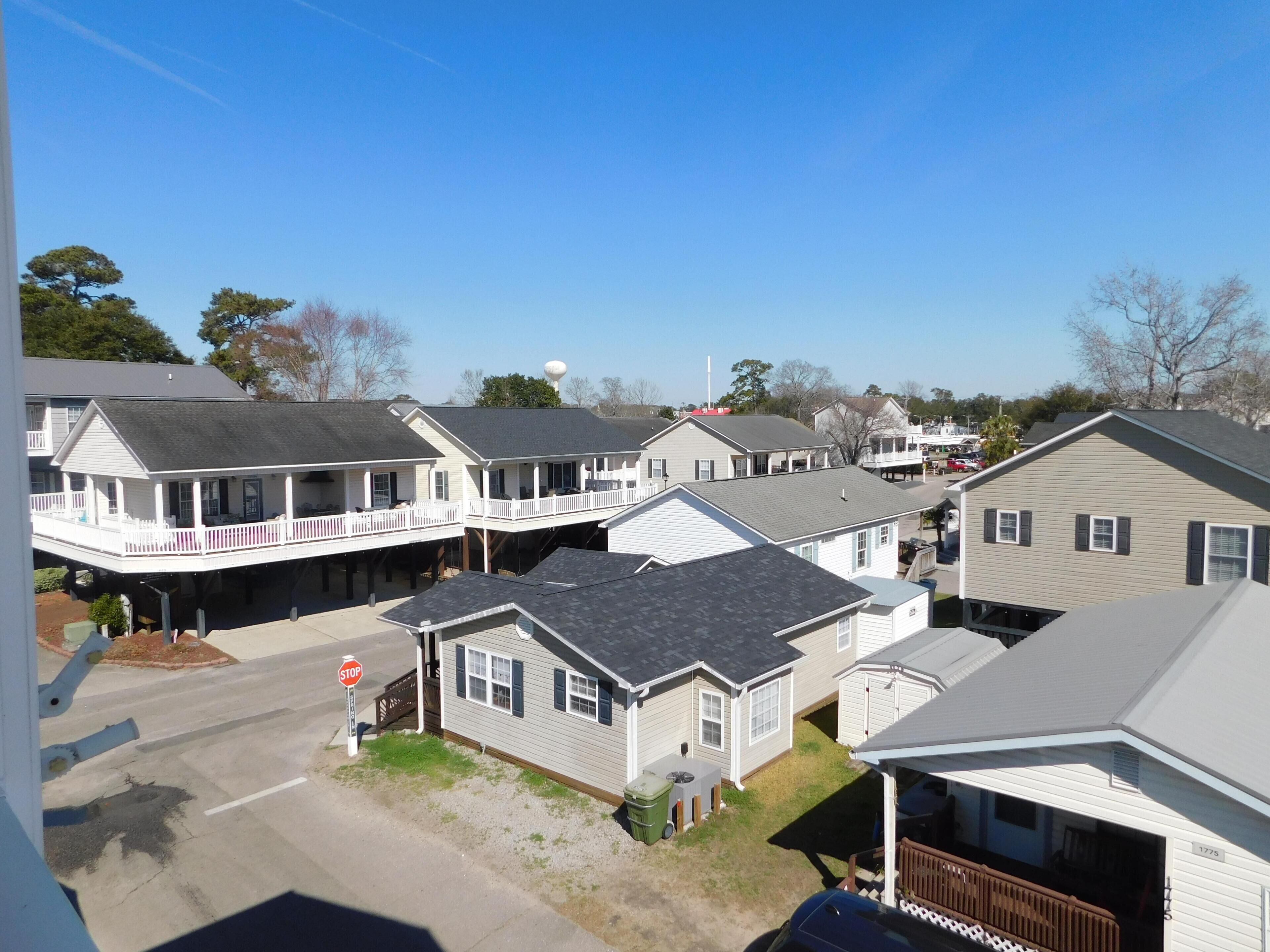 A residential area with multiple houses, a stop sign, and a clear sky.