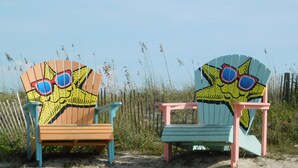Deux chaises de plage ornées de motifs de dessins animés et dotées de lunettes de soleil.