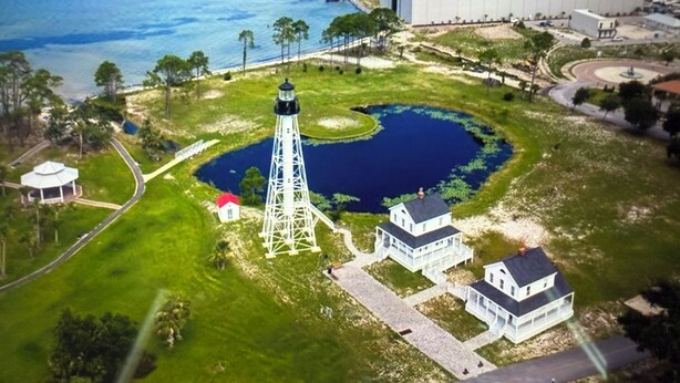 An aerial view of a coastal area with a lighthouse, a large building, and a pond. - Awesome  condo in The Marina. At Port St. Joe. 
 Bay views, exciting night life (Port St. Joe)