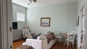A cozy living room with a sofa, chairs, a TV, and a painting on the wall. - Awesome  condo in The Marina. At Port St. Joe. 
 Bay views, exciting night life (Port St. Joe)