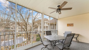 A covered balcony with a table and chairs, a ceiling fan, and a view of the neighborhood. - Recently Updated 2 Bedroom Condo in Pointe Royale Golf Village with King Beds (Branson)