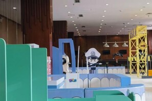 Un vestíbulo de hotel con una recepción, un área de estar y una estructura decorativa amarilla.