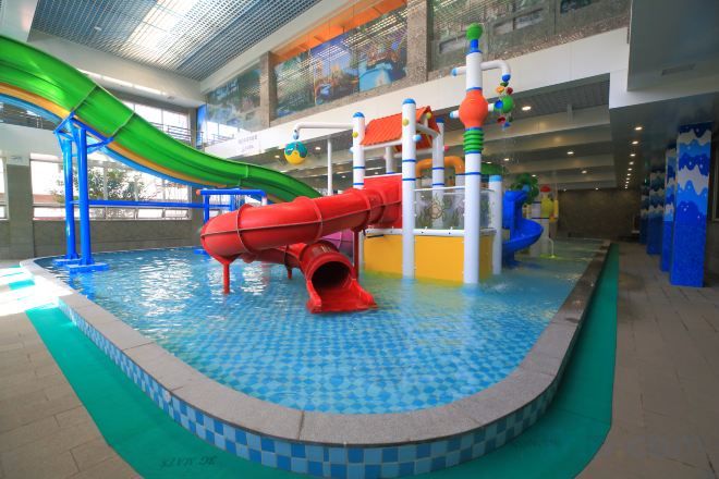 Un área de juegos acuáticos en interiores con toboganes y estructuras recreativas.