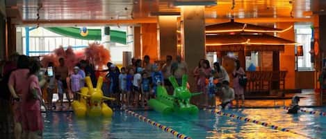 An indoor swimming pool with lanes, surrounded by spectators.