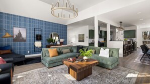A modern living room with a sectional sofa, a coffee table, and a blue plaid wall.