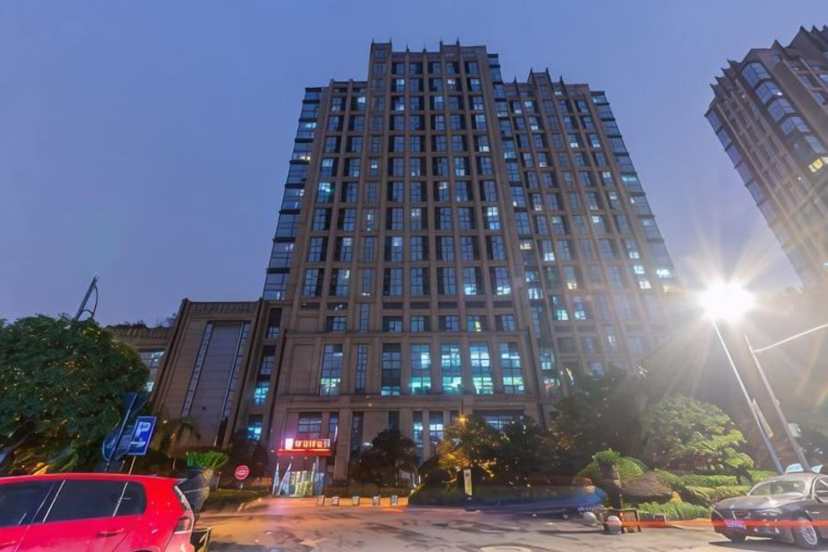 Un hotel de varios pisos con diseño moderno, que destaca por una entrada imponente y una fachada bien iluminada.