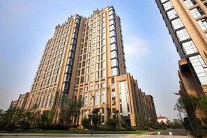 Un edificio de gran altura con varios pisos, ventanas amplias y fachada estructurada.