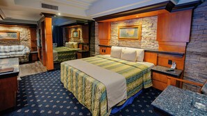 Een hotelkamer met een groot bed, een bureau en een zithoek.
