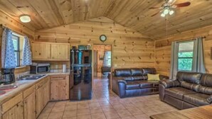 A log cabin interior with a kitchen, dining area, and living room. - Cozy cabin 1 bedroom, WiFi, AC above Sylamore Creek in welcoming Mountain View (Mountain View)