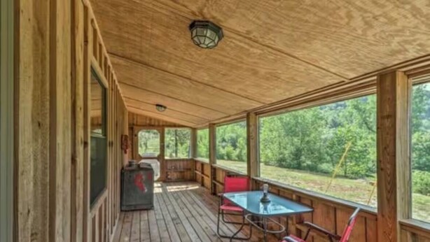 A wooden deck with a table and chairs, a bench, and a view of the outdoors. - Cozy cabin 1 bedroom, WiFi, AC above Sylamore Creek in welcoming Mountain View (Mountain View)