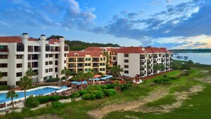 Ein Resort mit mehreren Gebäuden, einem Schwimmbad und Blick auf das Wasser.