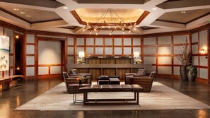 Un'ampia hall con un'area salotto centrale, una reception e un moderno lampadario.