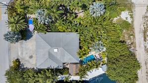 An aerial view of a house with a swimming pool, surrounded by dense tropical vegetation. - Tropical paradise on canal in Lower Keys-pool, tiki, firepit, dock, dog friendly (Summerland Key)