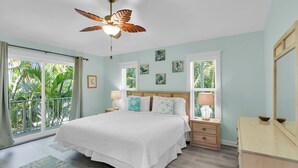 A bedroom with a bed, a ceiling fan, a nightstand, a dresser, and artwork on the walls. - Tropical paradise on canal in Lower Keys-pool, tiki, firepit, dock, dog friendly (Summerland Key)
