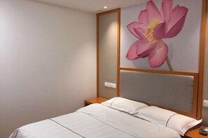 A hotel room with a bed, a nightstand, and a large floral artwork on the wall. - Laisili Hotel (Shanghai)