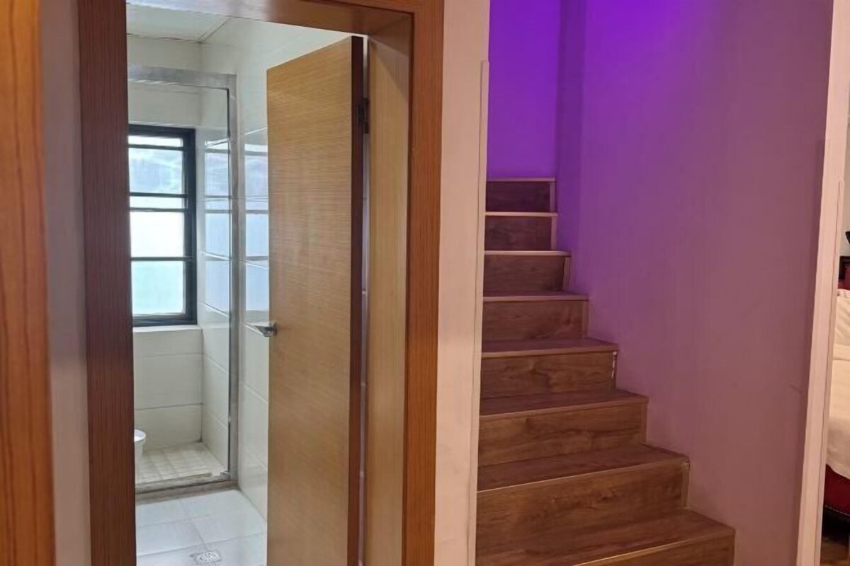 A wooden staircase leading to a room with a window and a door.