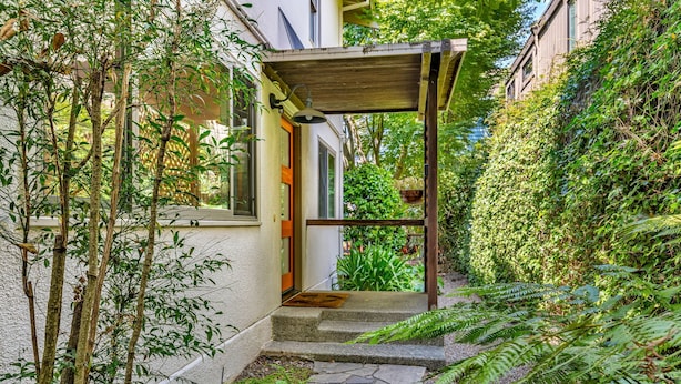 A covered outdoor area with a stone pathway leading to a door, surrounded by lush greenery and plants. - Mill Valley Apartment: Walking Distance to DT (Mill Valley)