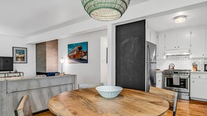 A modern kitchen with white cabinets, a stainless steel refrigerator, and a built-in oven. - Mill Valley Apartment: Walking Distance to DT (Mill Valley)