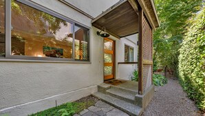 A modern house with a wooden porch, a stone pathway, and a garden. - Mill Valley Apartment: Walking Distance to DT (Mill Valley)