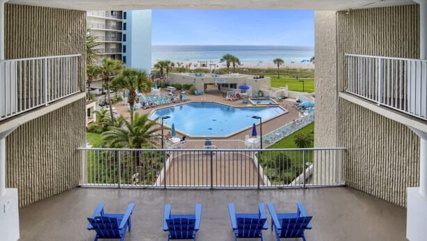 Ein Balkon mit Blick auf Pool und Strand.