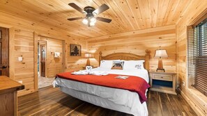 Cozy bedroom with a large bed, bedside tables, and a ceiling fan, offering a warm and inviting atmosphere.