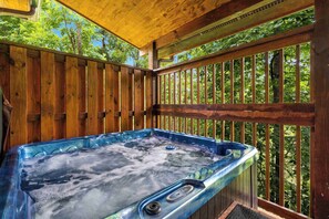 Relax in a hot tub surrounded by lush greenery.