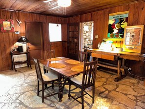 Ein Esszimmer mit Holzboden, einem Tisch mit Untersetzern und einem Vintage-Radio.