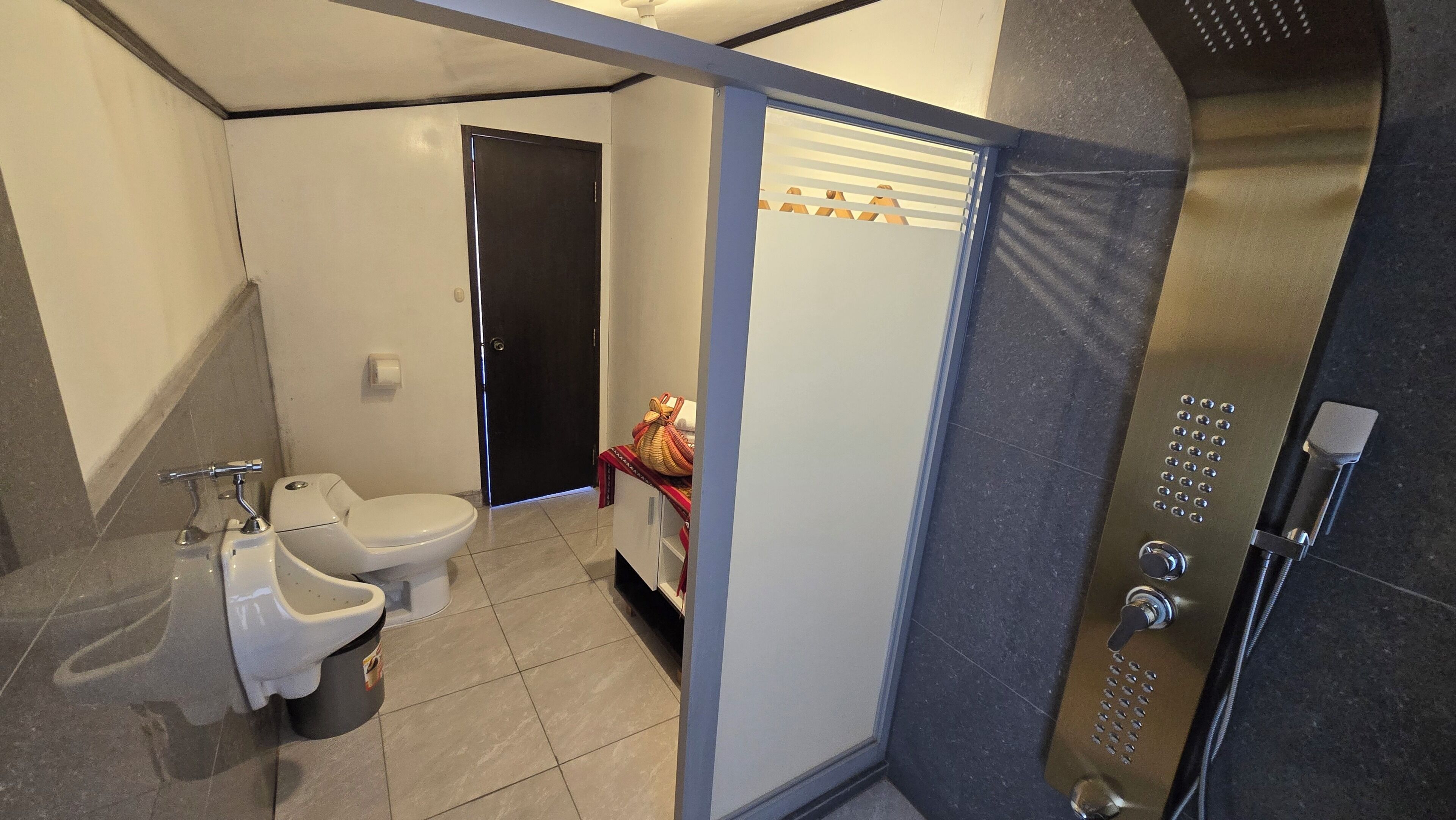 A bathroom with a toilet, bidet, and shower.