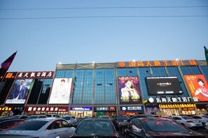 A multi-story commercial building with large digital billboards and signage. - Zhengzhou Yaxin Hotel (Leshang Plaza) (Zhengzhou)