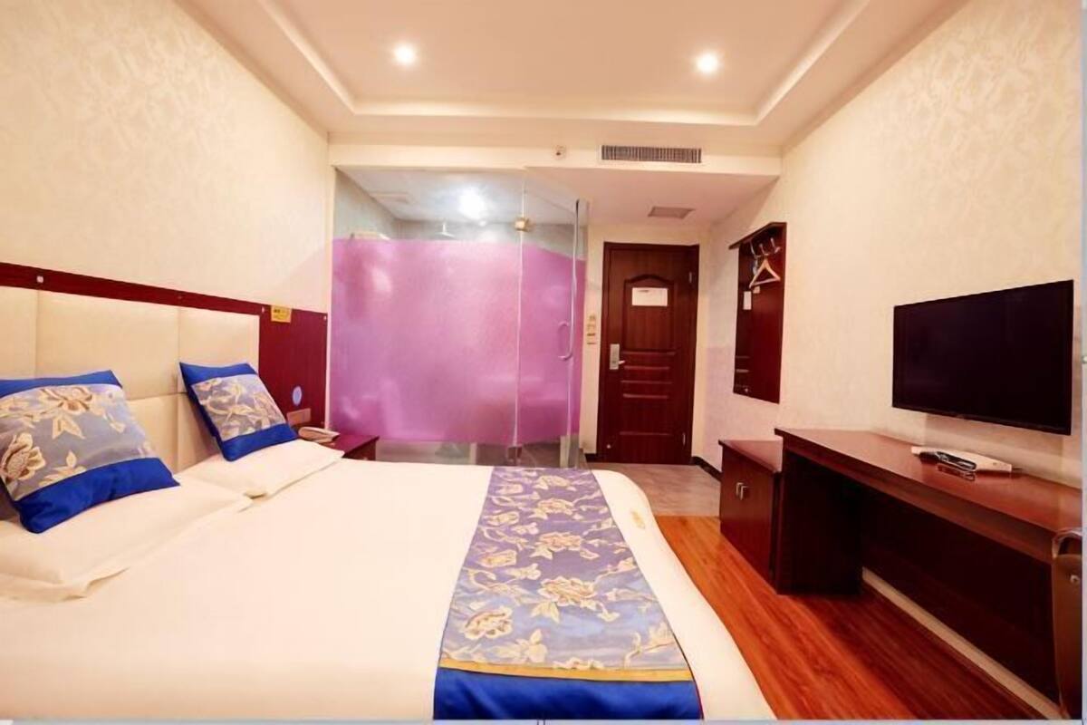 Une chambre d’hôtel équipée d’un lit, d’une télévision, d’un bureau et d’un miroir.